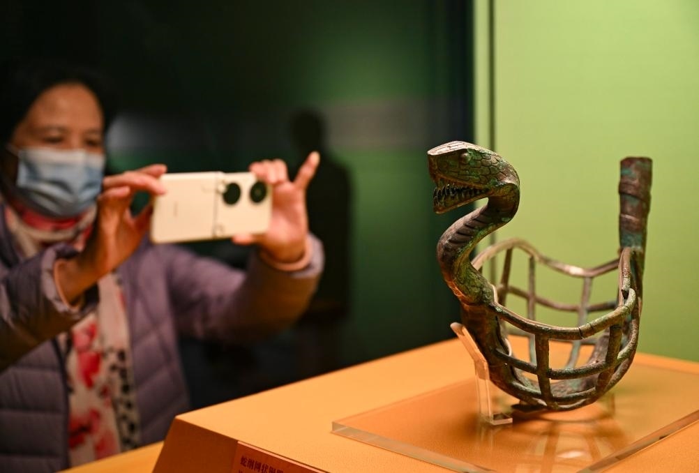 1月14日，觀眾在上海博物館蛇年迎春展拍攝展品蛇綱網(wǎng)狀銅器。新華社發(fā)（陳浩明攝）