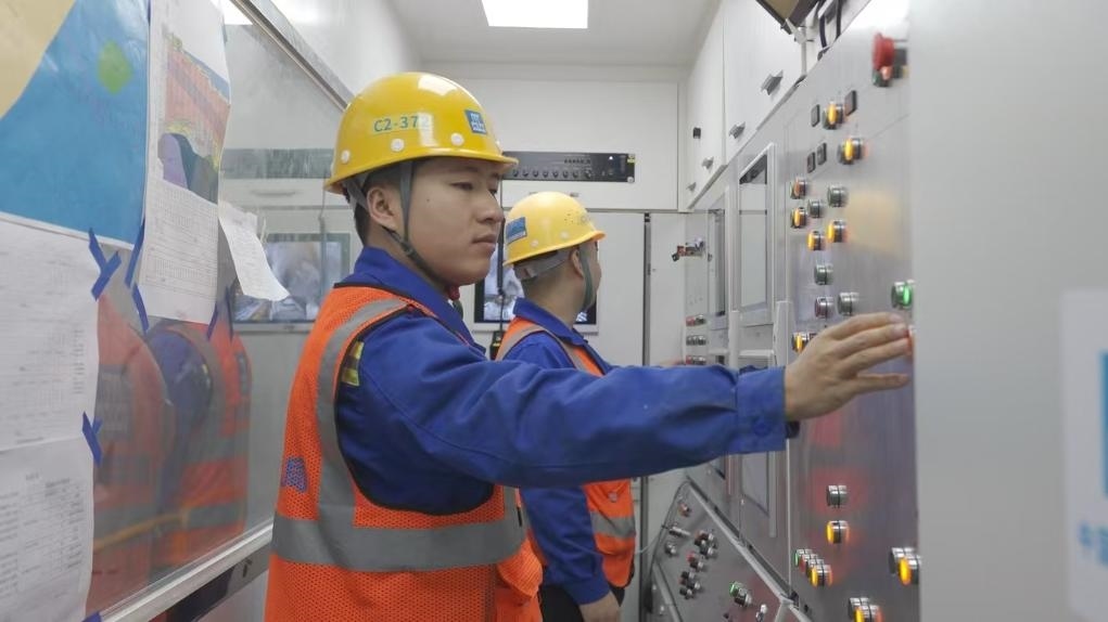 盾構(gòu)司機(jī)何曉波在駕駛室內(nèi)調(diào)試盾構(gòu)機(jī)參數(shù)。（劉芬攝）