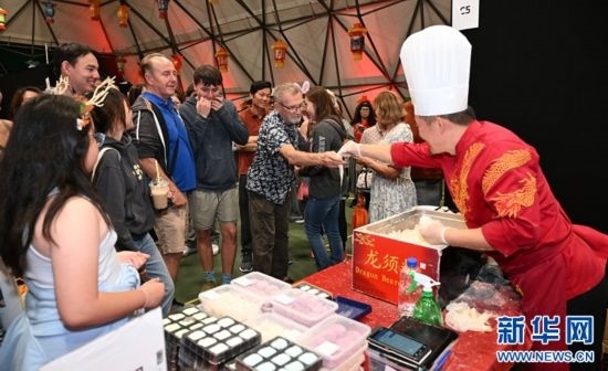 圖為游客在燈節(jié)現(xiàn)場(chǎng)購(gòu)買小吃。（圖片由奧克蘭中國(guó)文化中心提供）