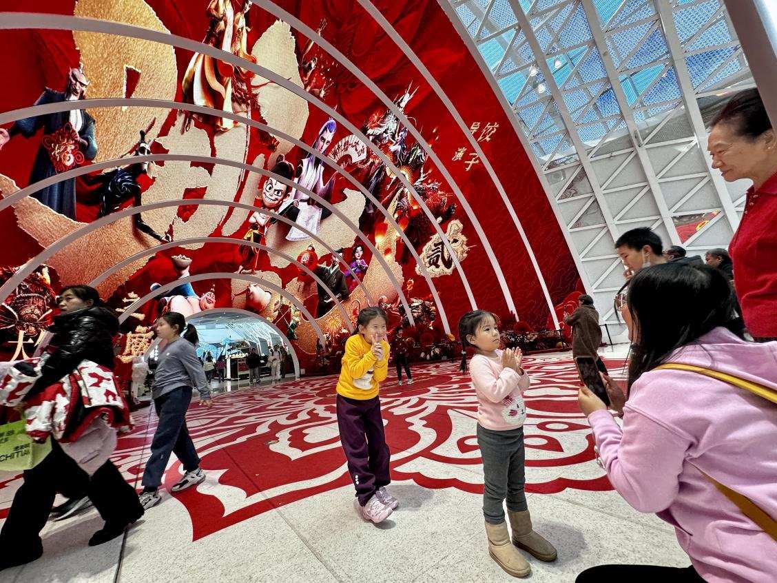 乙巳蛇年春節(jié)期間，影迷在《哪吒之魔童鬧?！肪薹?bào)前拍照打卡。