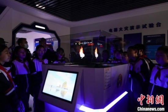 圖為學生們參觀道里區(qū)消防救援大隊消防科普體驗館內(nèi)幻影成像燃燒三要素實驗臺。中新社記者 趙宇航 攝