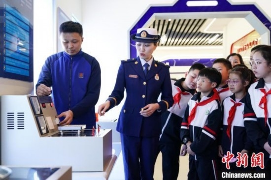 圖為學生們參觀道里區(qū)消防救援大隊消防科普體驗館內(nèi)電器火災演示實驗臺。中新社記者 趙宇航 攝