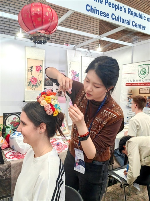 展覽正值羅馬尼亞迎春花節(jié)，國際中文教師志愿者潘婧穎向游客們介紹了國家非物質文化遺產——福建泉州的簪花文化。布加勒斯特大學孔子學院供圖。