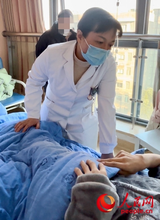 鄧茜查房時(shí)詢問患者情況。人民網(wǎng)記者 金慧慧攝