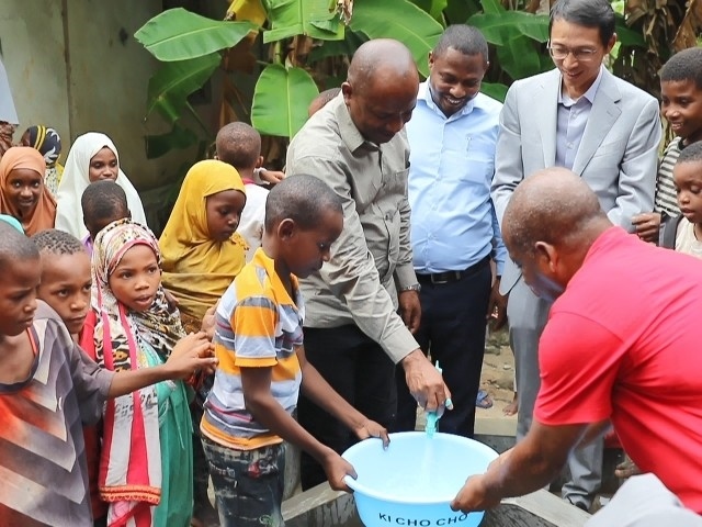 在日前舉行的安全供水工程揭牌儀式上，當(dāng)?shù)匦∨笥言诠┧c(diǎn)接水。 施亮攝