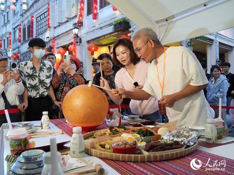 嘉賓品嘗海南傳統(tǒng)美食“煎堆”。人民網(wǎng)記者 張力洋攝