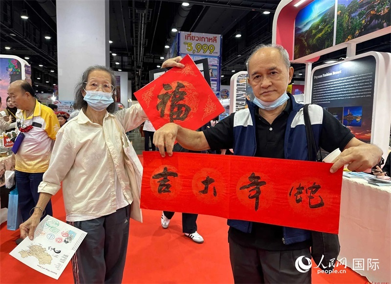 2025蛇年春節(jié)，泰國(guó)市民展示他們領(lǐng)到的華人手寫(xiě)春聯(lián)。人民網(wǎng)記者 簡(jiǎn)承淵攝