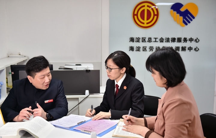 2025年3月6日，在北京市海淀區(qū)總工會勞動爭議調(diào)解中心，海淀區(qū)人民法院法官王琰（中）與該中心工作人員就糾紛化解情況進行溝通。新華社記者 趙婷婷 攝