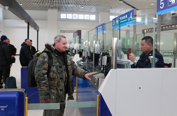 2024年12月10日，在黑河公路口岸旅檢大廳，黑河出入境邊防檢查站民警為首班次客車入境旅客辦理邊檢通關(guān)手續(xù)。當(dāng)日，中國黑河公路口岸—俄羅斯卡尼庫爾干公路口岸旅客運(yùn)輸正式開通。新華社發(fā)（劉松攝）