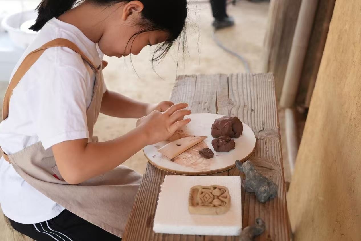 游客制作良渚特色陶藝品。良渚博物院供圖