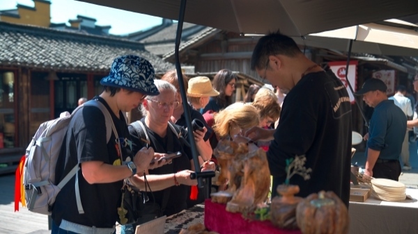 “五一”期間，游客正在烏鎮(zhèn)“水鄉(xiāng)碼頭”挑選購買文創(chuàng)產(chǎn)品。受訪者供圖