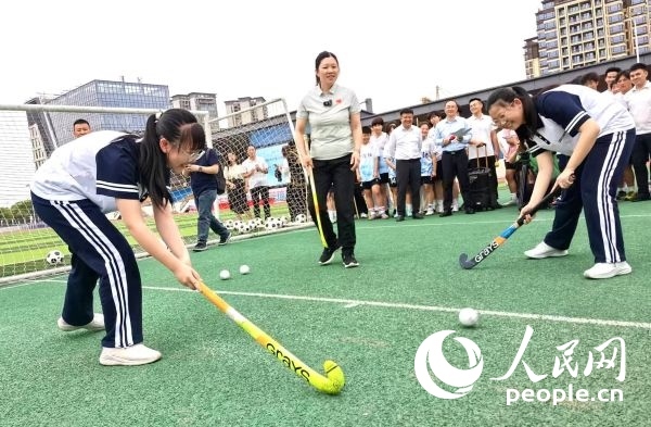 陳朝霞（中）指導(dǎo)學(xué)生體驗(yàn)曲棍球。 人民網(wǎng)記者 楊磊攝