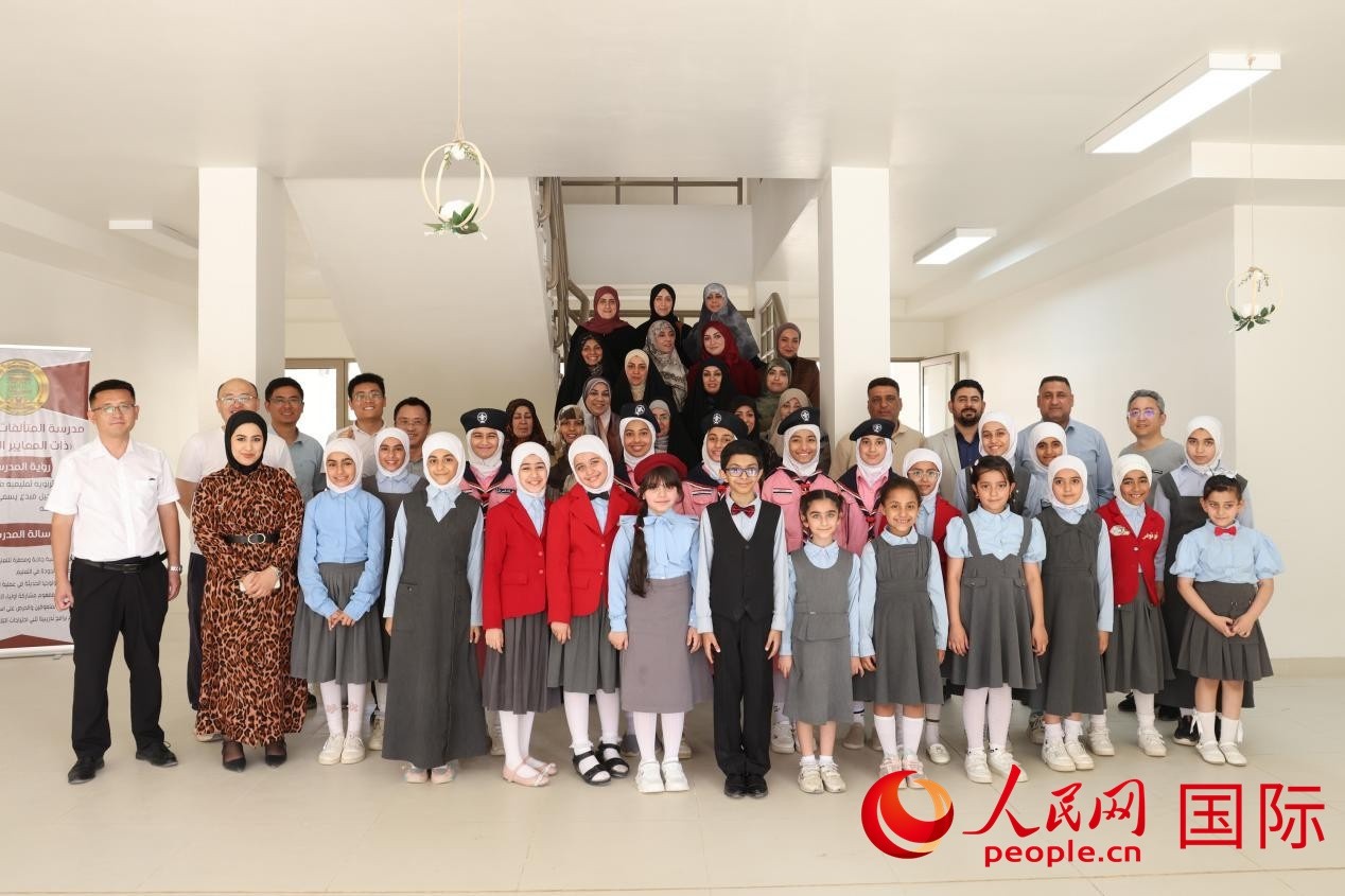 中國電建員工與阿爾穆塔?阿里卡特國際學(xué)校的師生及政府官員等合影。人民網(wǎng)記者 薛丹攝