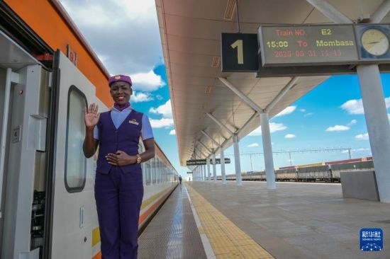 5月31日，在蒙內(nèi)鐵路內(nèi)羅畢站，一名乘務員在即將開往蒙巴薩的E2次列車旁等候乘客。新華社記者 楊光 攝