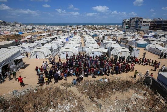 5月28日，人們在加沙城西部的沙提難民營等待領(lǐng)取救助食物。新華社發(fā)（里澤克·阿卜杜勒賈瓦德攝）