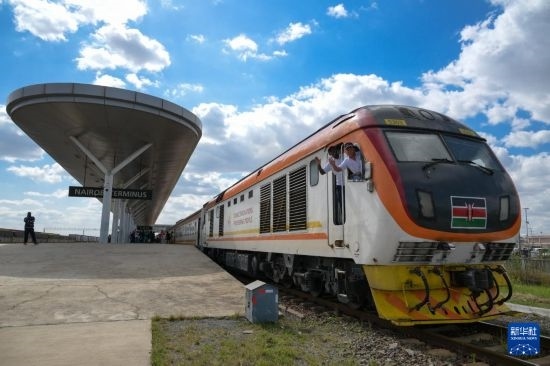 5月31日，在蒙內(nèi)鐵路內(nèi)羅畢站，機車駕駛員蔣立平（右）和博爾在即將開往蒙巴薩的E2次列車上揮手致意。新華社記者 楊光 攝