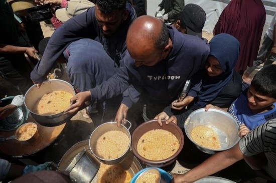 5月28日，人們在加沙城西部的沙提難民營領(lǐng)取救助食物。新華社發(fā)（里澤克·阿卜杜勒賈瓦德攝）