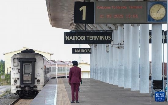 5月31日，在蒙內(nèi)鐵路內(nèi)羅畢站，工作人員目送開往蒙巴薩的E2次列車駛離站臺。新華社記者 李亞輝 攝